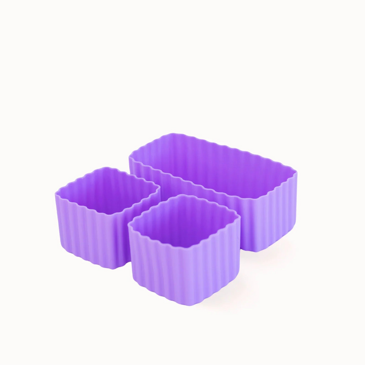 Three purple silicone baking molds on a white background