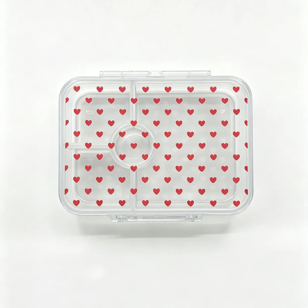 A clear plastic bento container with a lid patterned with small red hearts, shown from a top-down view on a white background.