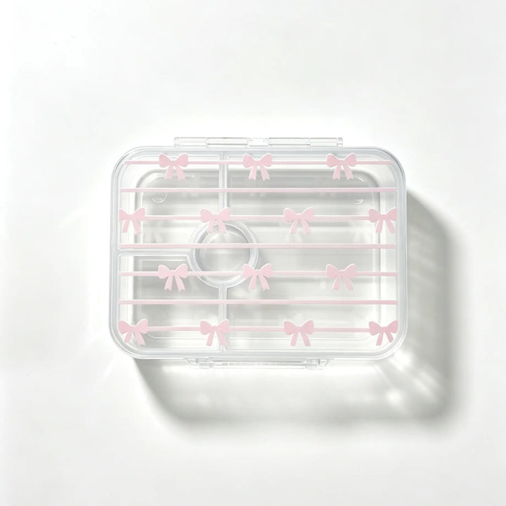 A clear plastic bento with a lid decorated with small pink bow patterns, shown on a clean white background with a soft shadow.